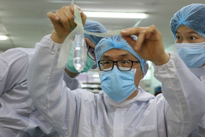 Bác sĩ John Tang Ing Ching kiểm tra bao cao su phi giới tính tại nhà máy Sibu, Malaysia ngày 19/10. Ảnh: Reuters