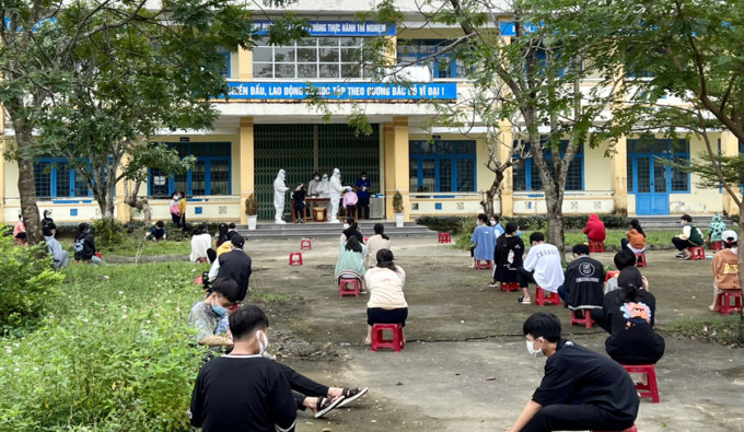 Lấy mẫu xét nghiệm Covid-19 cho học sinh Trường THCS Lê Thị Hồng Gấm, sáng 21/12. Ảnh: Đắc Thành.