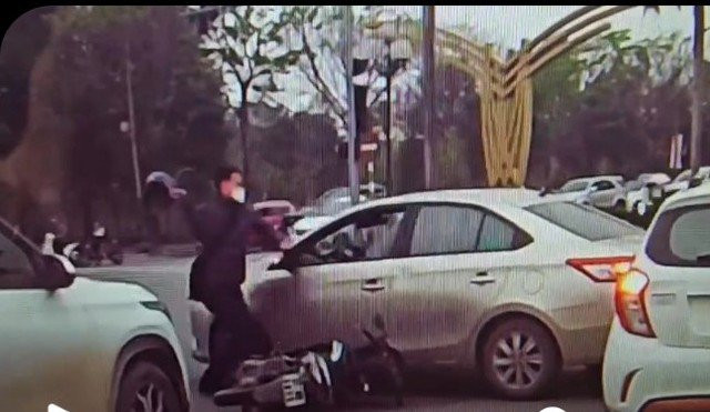 Hình ảnh người đàn ông dùng mũ bảo hiểm đập vỡ kính xe ôtô được người dân ghi lại