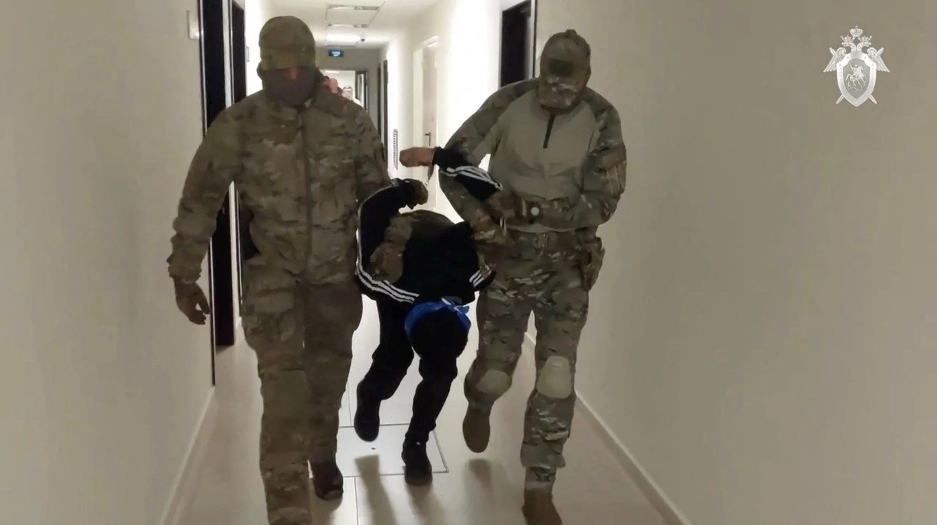 Cảnh sát Nga áp giải một nghi phạm trong vụ khủng bố hôm 23/3 (ảnh: TASS)