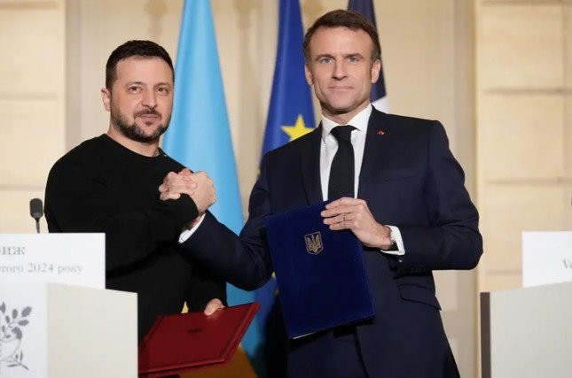 Tổng thống Pháp Emmanuel Macron và người đồng cấp Ukraine Volodymir Zelensky khi ký thỏa thuận an ninh tại Paris. (Ảnh: Reuters)