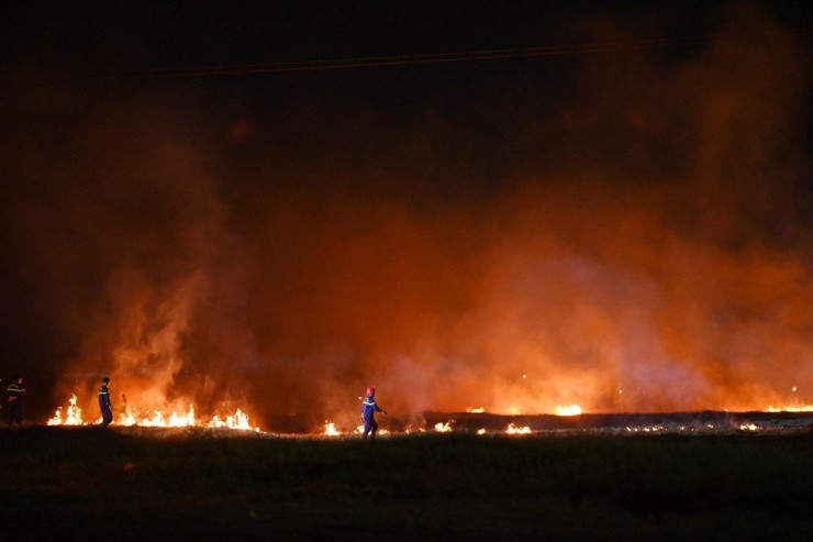 Đám cháy lan rộng ra khu vực lớn bên dưới lưới điện cao thế. Ảnh: CTV