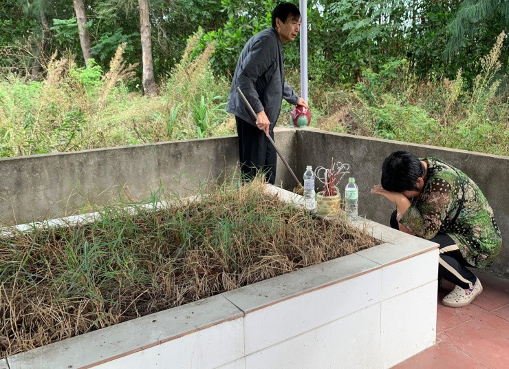 Hình ảnh bố mẹ hai nạn nhân từ Trung Quốc đến Hà Tĩnh thăm mộ các con.