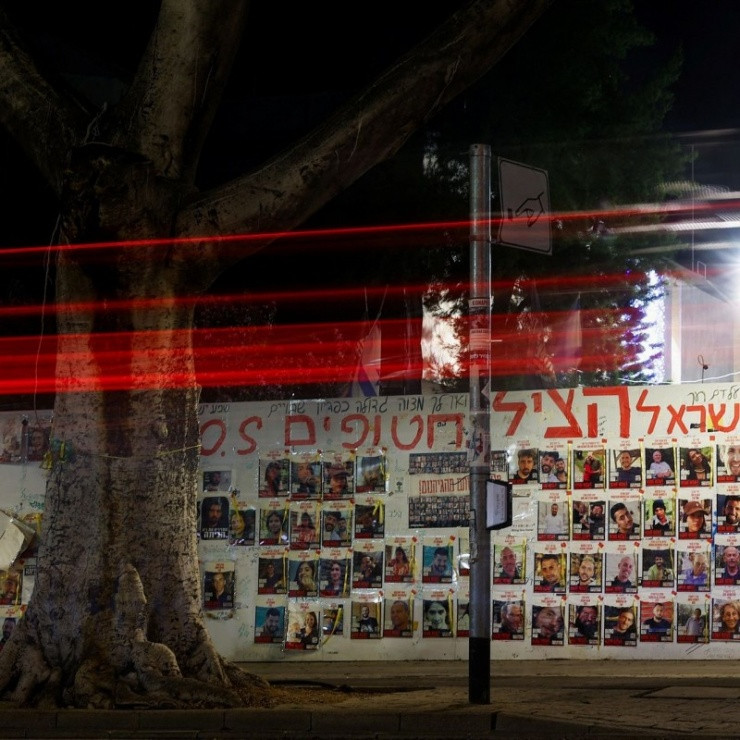 Một bức tường tại thủ đô Tel Aviv (Israel) dán ảnh của những con tin chưa được giải cứu cùng lời cầu nguyện cho họ sớm trở về - Ảnh: WSJ.