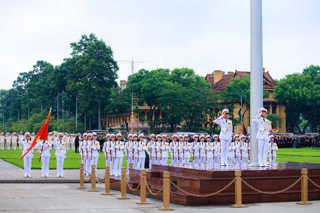 Đội tiêu binh làm lễ chào cờ sau khi lá Quốc kỳ gắn dải băng tang được treo lên 2/3 cột cờ