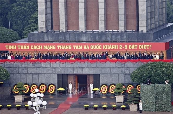 Các đồng chí lãnh đạo, nguyên lãnh đạo Đảng, Nhà nước, các vị khách quốc tế và các đại biểu thực hiện nghi lễ chào cờ. Ảnh: Doãn Tấn/TTXVN
