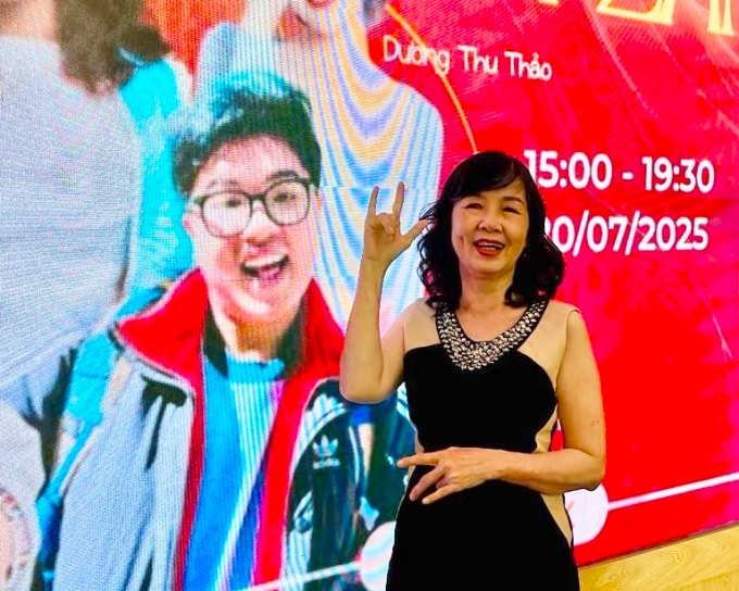 Mẹ của Đức Thiện ra dấu Mẹ yêu con bằng ngôn ngữ ký hiệu khi tham dự một sự kiện có con trai từ xa. Ảnh: Nhân vật cung cấp