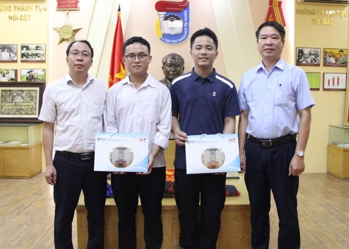 Ngô Quang Minh (áo xanh than) và Trần Minh Hoàng (bên cạnh) nhận quà từ GS.TS. Lê Thanh Sơn, Hiệu trưởng trường Đại học Khoa học Tự nhiên (phải) sau khi trúng tuyển lớp cử nhân tài năng. Ảnh: Fanpage nhà trường