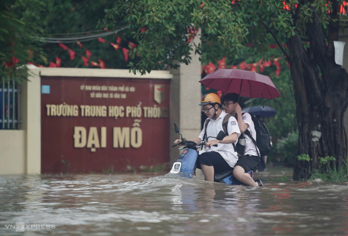 Học sinh Hà Nội tan trường trong cơn mưa lớn, đường ngập sâu, trưa 30/9. Ảnh: Hoàng Giang