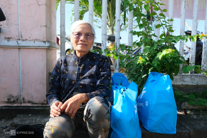 Bà Nguyễn Thị Hồng, 75 tuổi nhận quà Tết của Qũy Hy vọng tại nhà văn hóa thôn Phú Hội, xã Tuy An Đông, sáng 5/2. Ảnh: Quỳnh Nguyễn