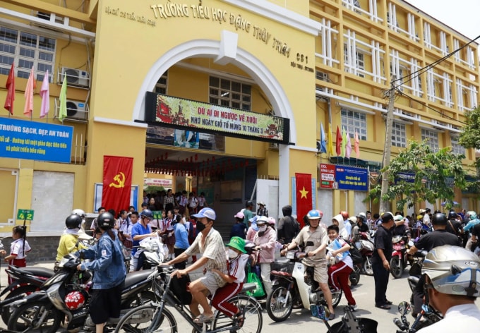 Phụ huynh đưa đón học sinh trường Tiểu học Đặng Thùy Trâm, phường Tân Thuận, về giữa trưa 29/4. Ảnh: Nguyệt Minh