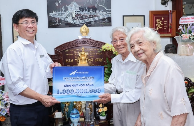 Thầy Đoàn Văn Điện cùng vợ trao quỹ học bổng 1 tỷ đồng cho ông Lâm Thành Hiển, Hiệu trưởng trường Đại học Lạc Hồng, ngày 5/5. Ảnh: LHU