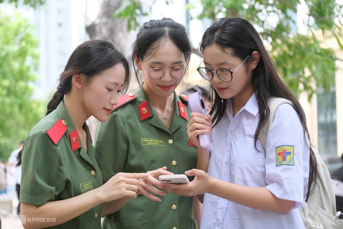 Học viên Học viện An ninh nhân dân hướng dẫn thí sinh vào phòng thi, chiều 20/6. Ảnh: Dương Tâm