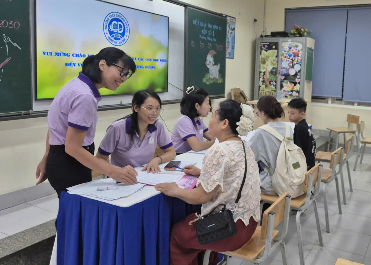 Cán bộ, giáo viên Trường THCS Chương Dương (phường Hồng Hà) hỗ trợ phụ huynh học sinh đăng ký tuyển sinh vào lớp 6 năm học 2026-2027. Ảnh: Lê Nguyễn