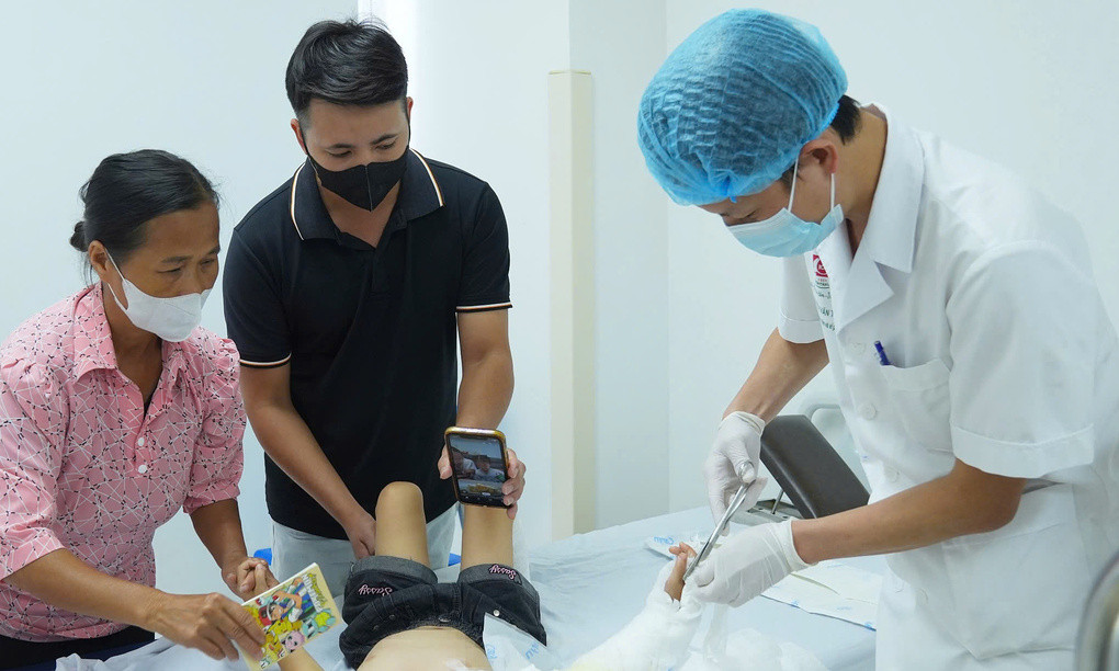 Bác sĩ kiểm tra vết thương cho bệnh nhi. Ảnh: An Ngọc