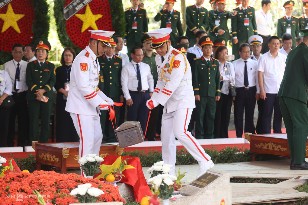 Quân nhân hạ huyệt tiểu quách đặt hài cốt liệt sĩ xuống lòng đất tại Nghĩa trang liệt sĩ TP HCM. Ảnh: Quỳnh Trần