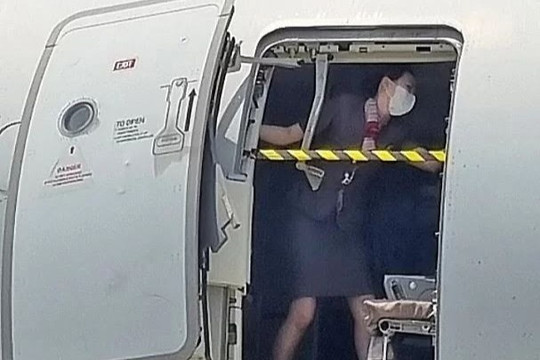 Nữ tiếp viên hàng không che chắn trước cánh cửa máy bay bị mở tung