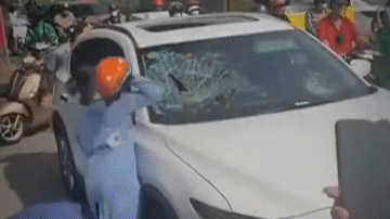 Clip người phụ nữ cầm mũ bảo hiểm đập nát kính ô tô giữa phố