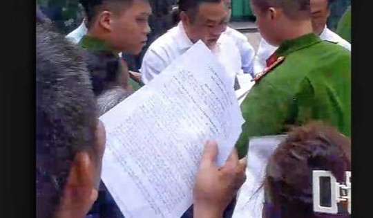 Chủ tịch Hà Nội Trần Sỹ Thanh cúi người nhặt tờ đơn của người dân bị rơi