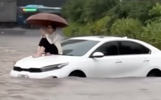 Ung dung ngồi trên nắp capo ô tô bị ngập nước, người phụ nữ lý giải nguyên nhân