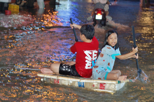 Triều cường vượt mức báo động, người dân Cần Thơ cho con bơi bè qua đường đi học