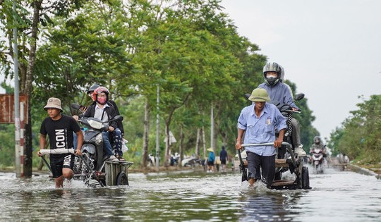 Người dân qua đại lộ Thăng Long bỏ 50.000 đồng/lượt xe bò để ‘vượt ngập’